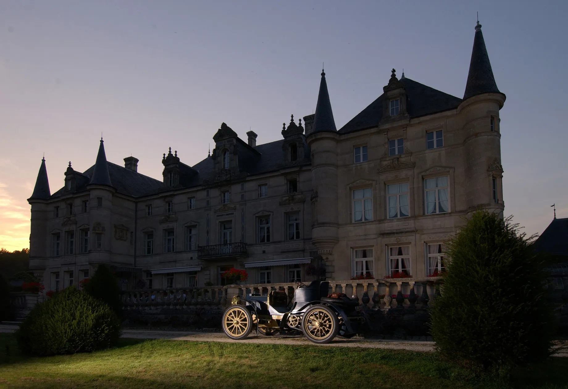 Le château au crépuscule, automobile de collection devant la terrasse
