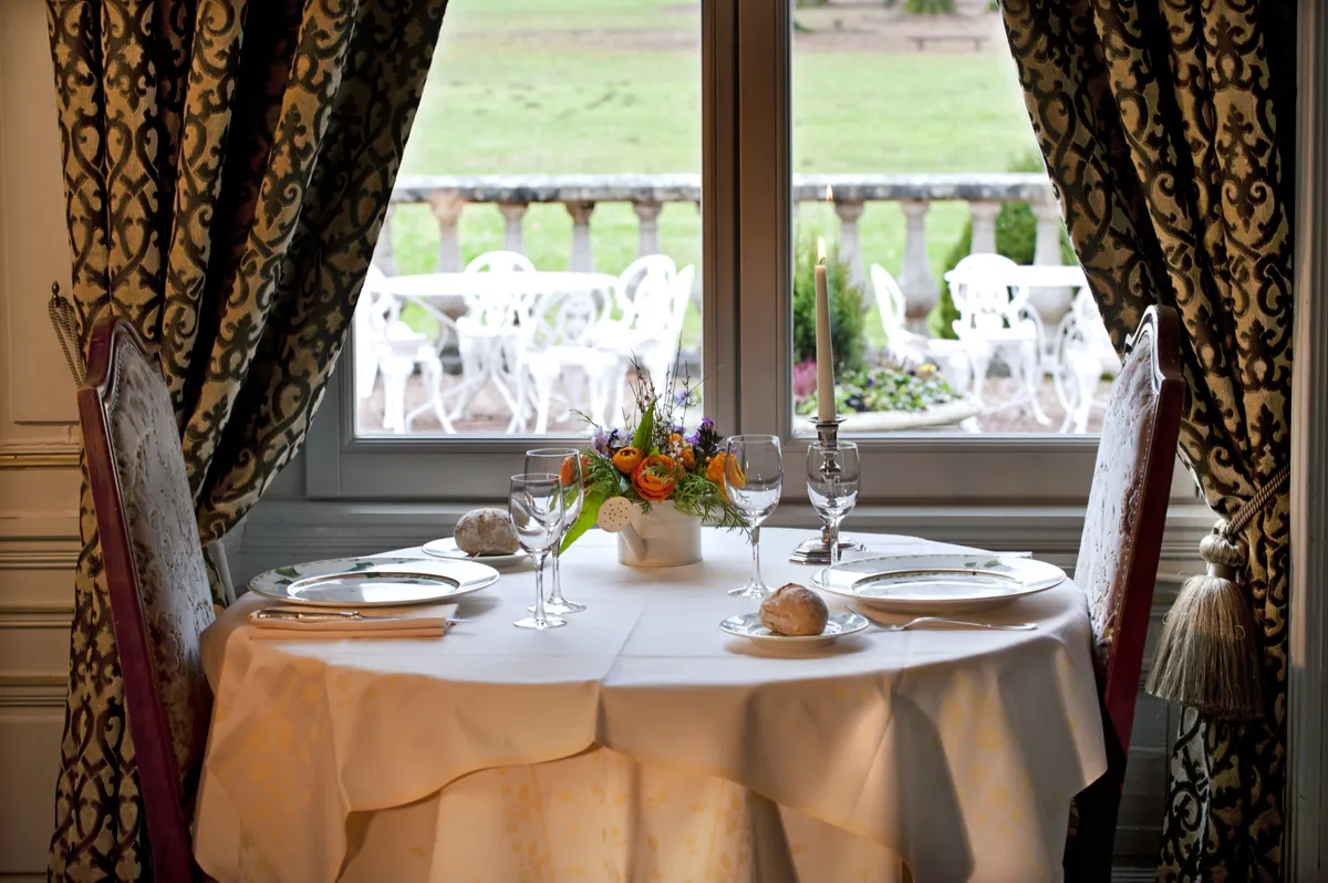 Table dressée face au parc, au restaurant du château